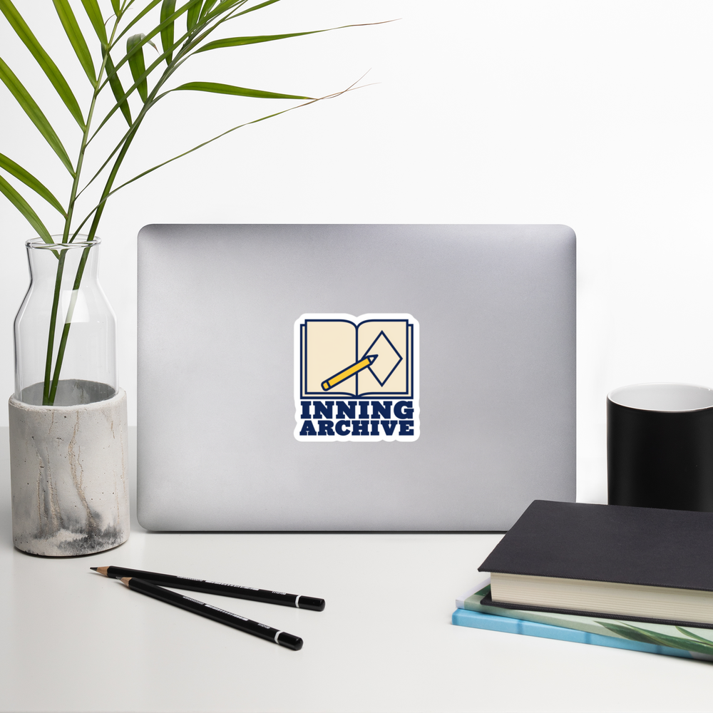INNING ARCHIVE 4 inch baseball sticker on a laptop in a front-facing indoor desk scene with books, a mug and a plant. Styling props are not included.