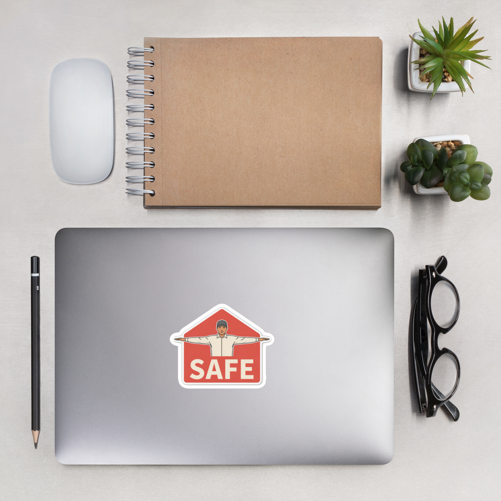 SAFE 4 inch baseball sticker on a laptop in an overhead indoor desk with laptop, notebook, mouse, glasses and plants. Styling props are not included.
