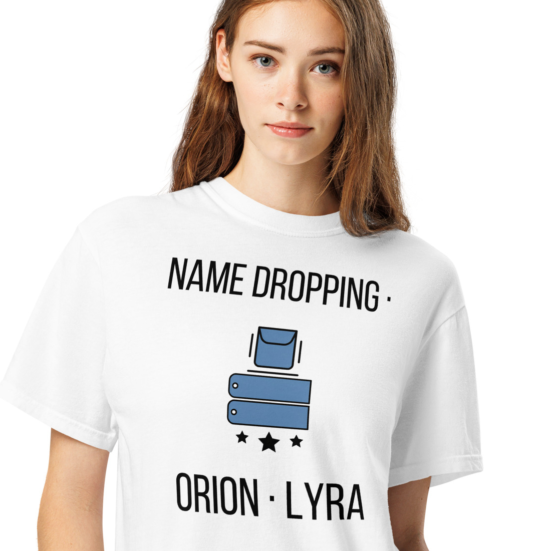 Woman wearing a White orion constellation shirt printed with two name tags dropping from a pocket above three stars between the words NAME DROPPING and ORION · LYRA