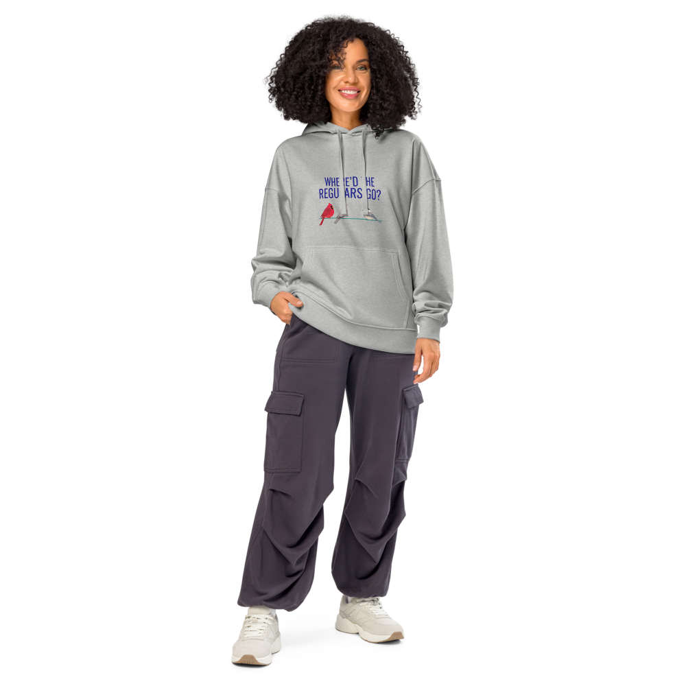 Woman wearing the Heather Grey backyard bird hoodie with WHERE'D THE REGULARS GO? above three birds with a gap