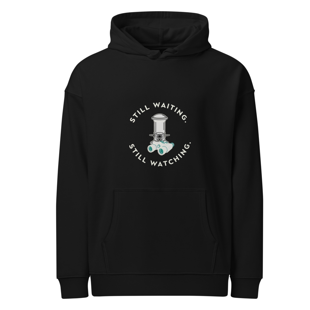 Bird Hoodie in Black, front view: STILL WAITING. STILL WATCHING. around a feeder and binoculars