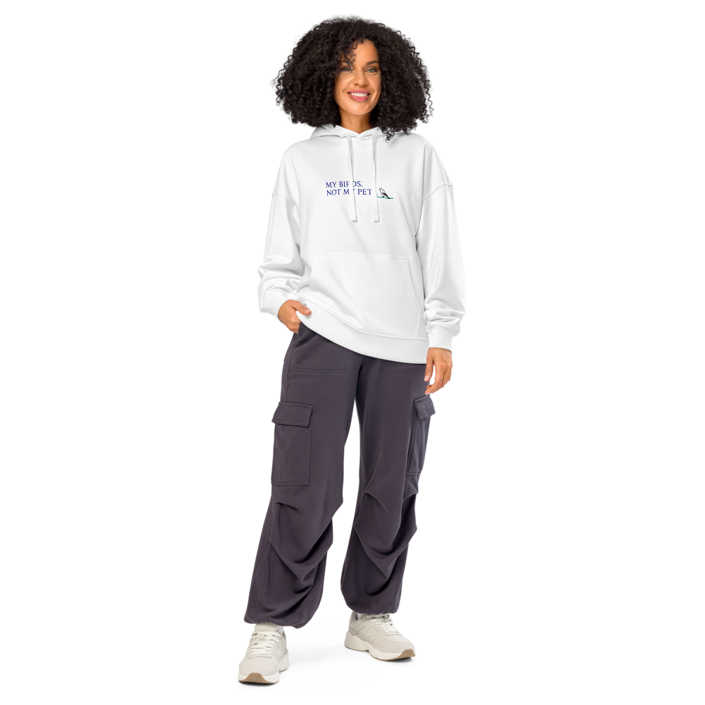 Woman wearing the white bird lady hoodie with MY BIRDS. NOT MY PETS. with a small songbird