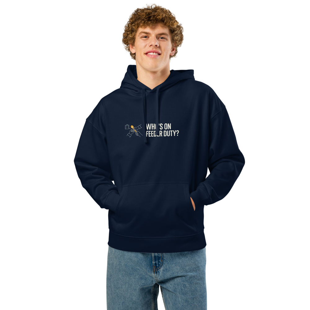 Man wearing the French Navy bird lover hoodie with two hands passing a seed scoop beside WHO'S ON FEEDER DUTY?