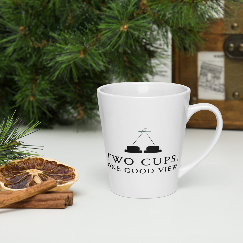 Bird lover latte mug on a table with pine branches, dried orange and cinnamon, showing two seats watching one bird over TWO CUPS, ONE GOOD VIEW