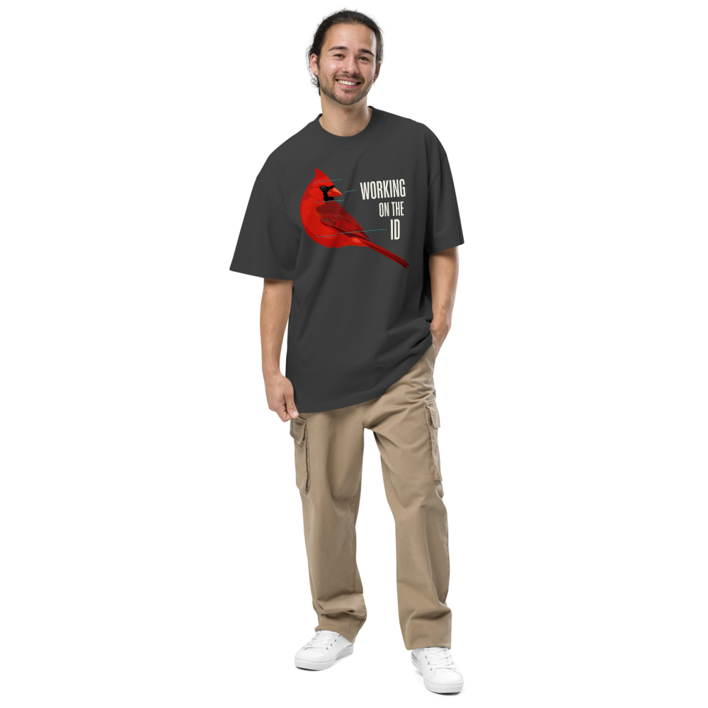 Man wearing the faded black bird nerd shirt with a cardinal with field-mark notes beside WORKING ON THE ID