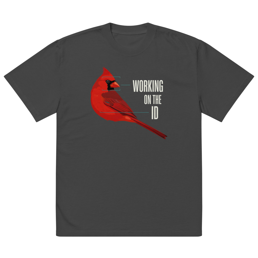 The faded black bird nerd shirt laid flat, showing a cardinal with field-mark notes beside WORKING ON THE ID