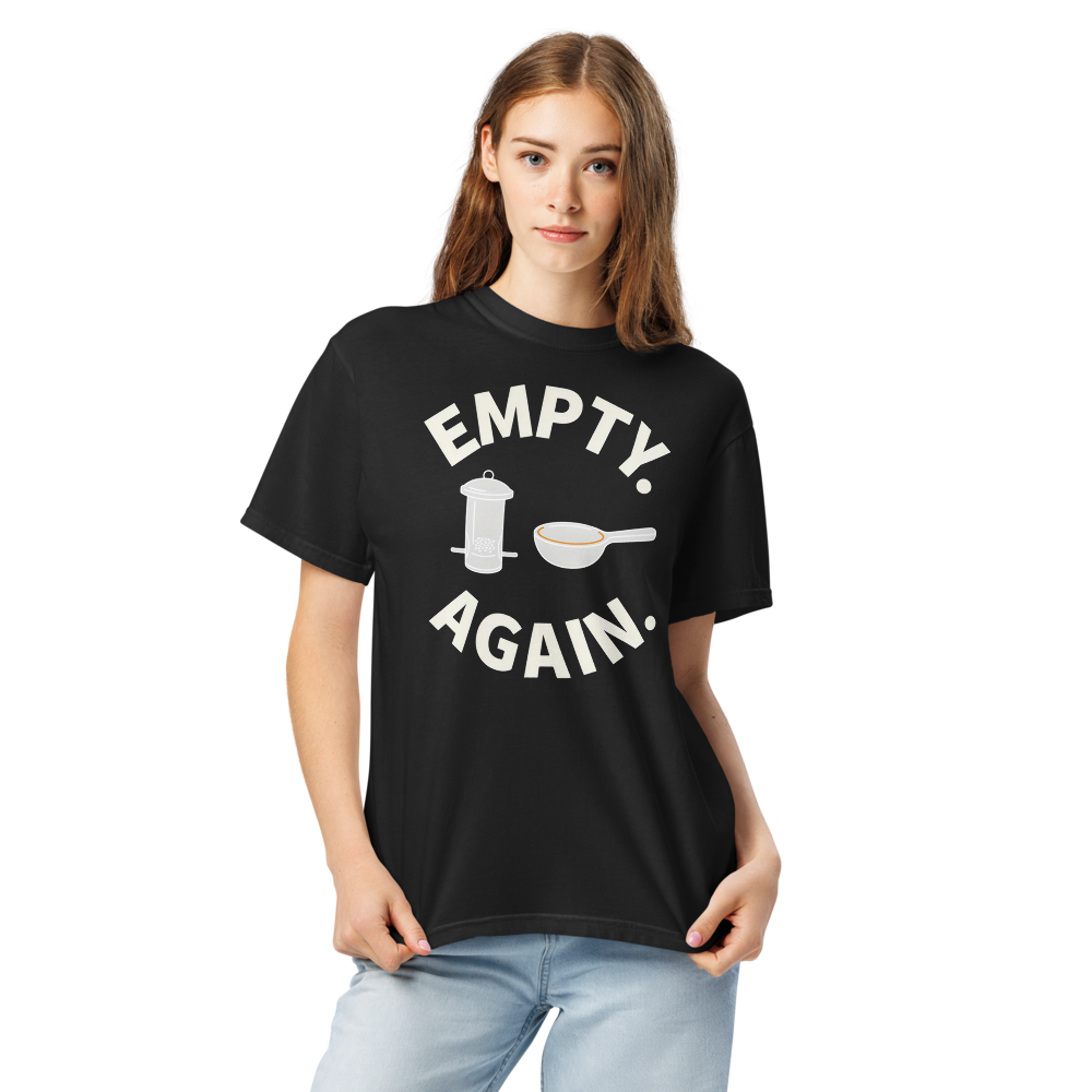 Close-up of a woman in the black bird shirt for women, showing EMPTY. AGAIN. curved around a feeder and scoop