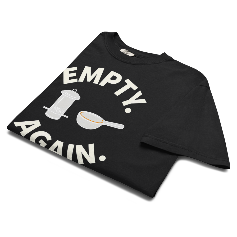 The black bird shirt for women folded, showing EMPTY. AGAIN. curved around a feeder and scoop