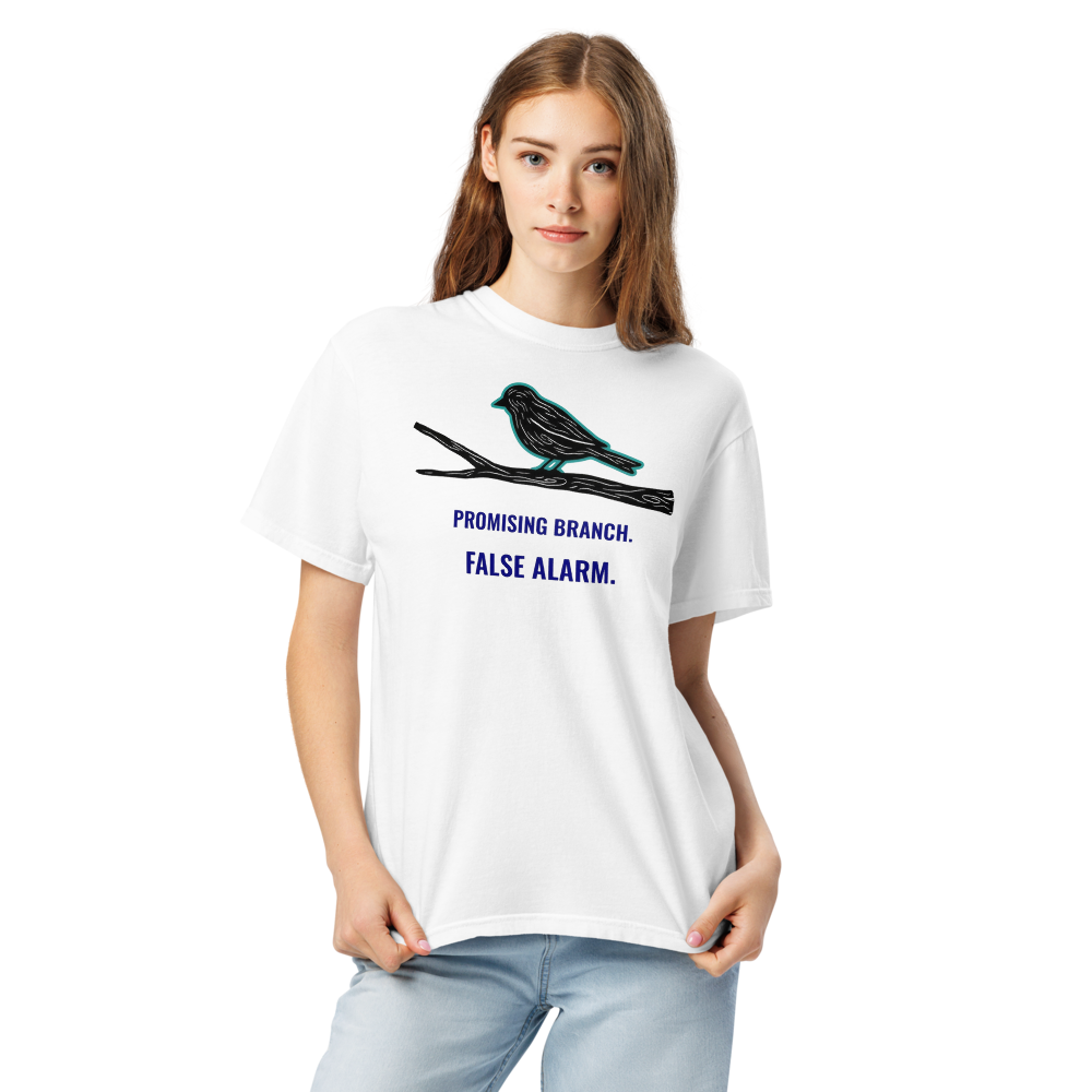 Close-up of a woman in the white bird watching shirt, showing a bird-shaped branch above PROMISING BRANCH. FALSE ALARM.