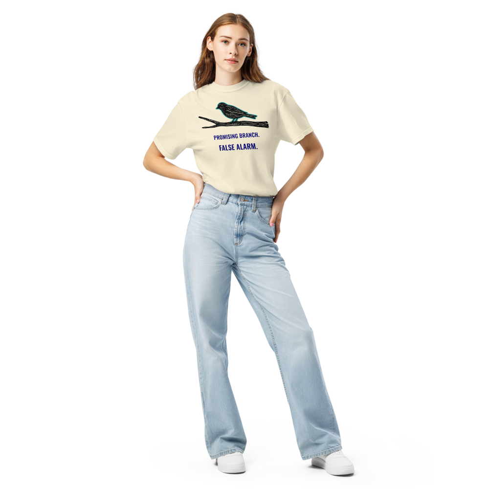 Woman wearing the Ivory bird watching shirt with a bird-shaped branch above PROMISING BRANCH. FALSE ALARM.