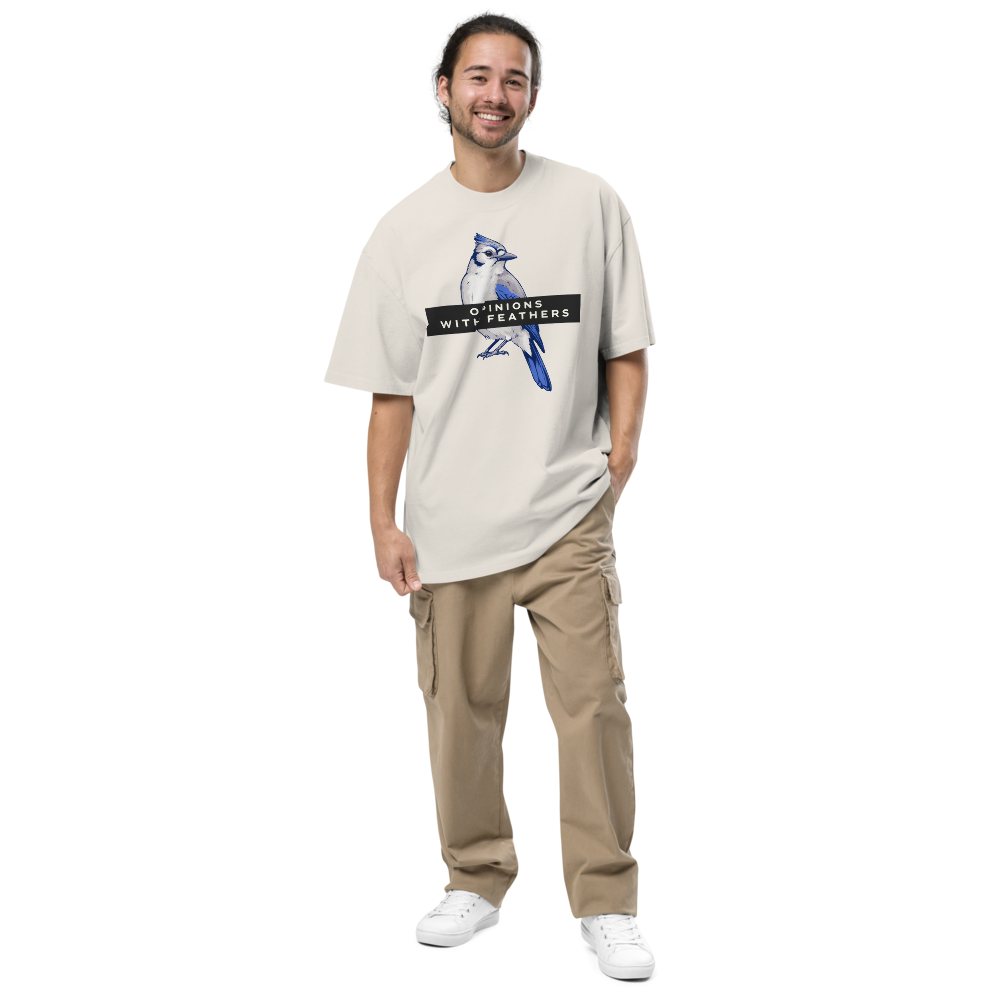 Man wearing the faded bone blue jay shirt with a blue jay under an OPINIONS WITH FEATHERS banner