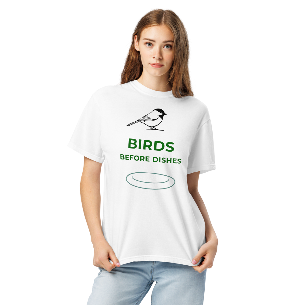 Close-up of a woman in the white chickadee shirt, showing a chickadee above BIRDS BEFORE DISHES and a plate outline