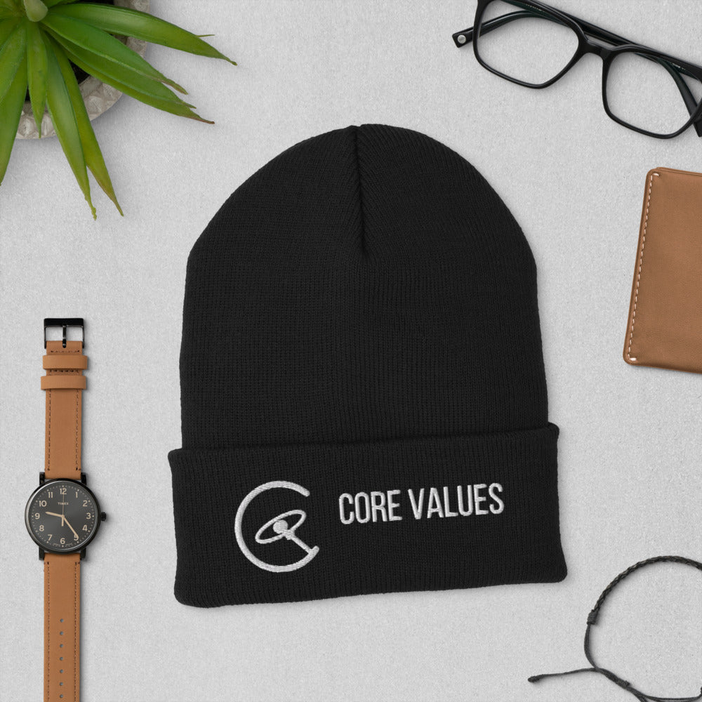 Black Core Values galaxy beanie laid flat beside a watch, glasses and a leather wallet