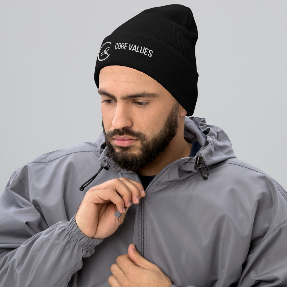 Bearded man in a gray jacket wearing the black Core Values galaxy beanie with white embroidery on the cuff