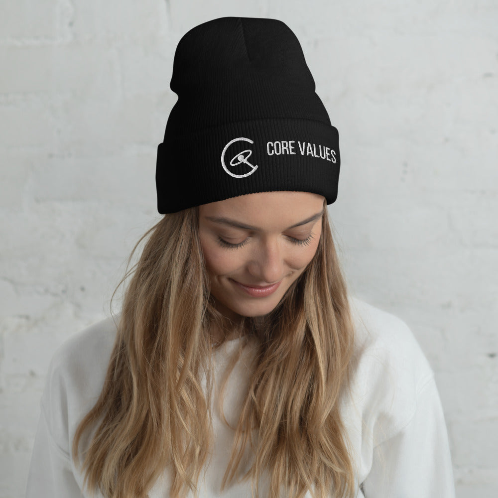 Woman with long hair glancing down while wearing the black Core Values galaxy-compass beanie