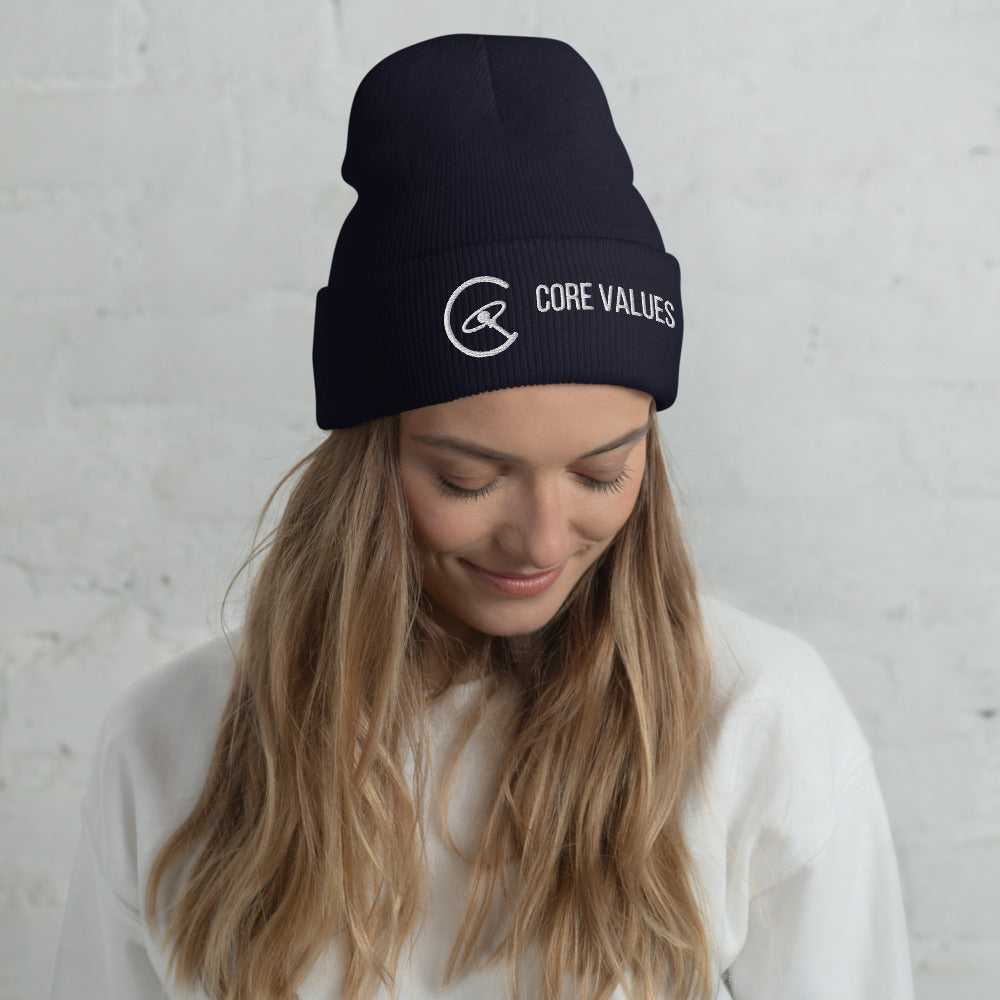Woman with long hair glancing down while wearing the navy Core Values galaxy-compass beanie