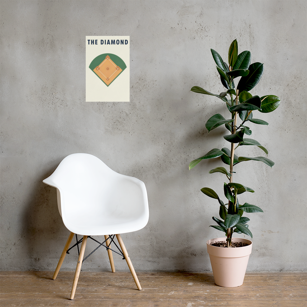 The Diamond unframed baseball field poster on a wall beside a white chair and potted plant; room props are not included. The mockup shows the 12 by 18 inch size.