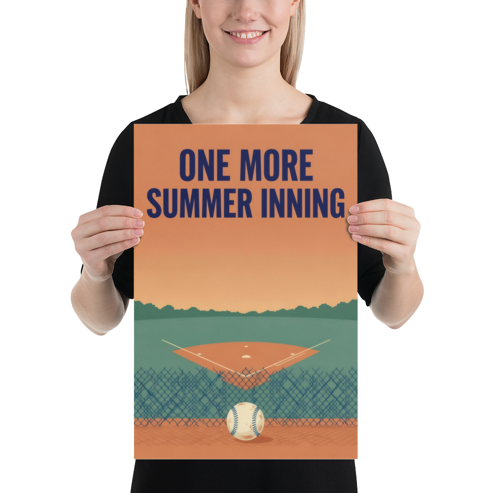 Person holding the 12 by 18 inch unframed One More Summer Inning poster, with its navy title, sunset field and foreground baseball.