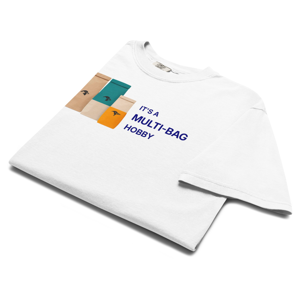 The white funny bird shirt folded, showing three seed bags beside IT'S A MULTI-BAG HOBBY