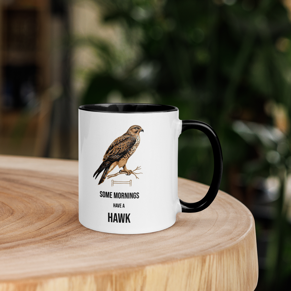 Hawk mug with black inside on a wooden table with plants behind