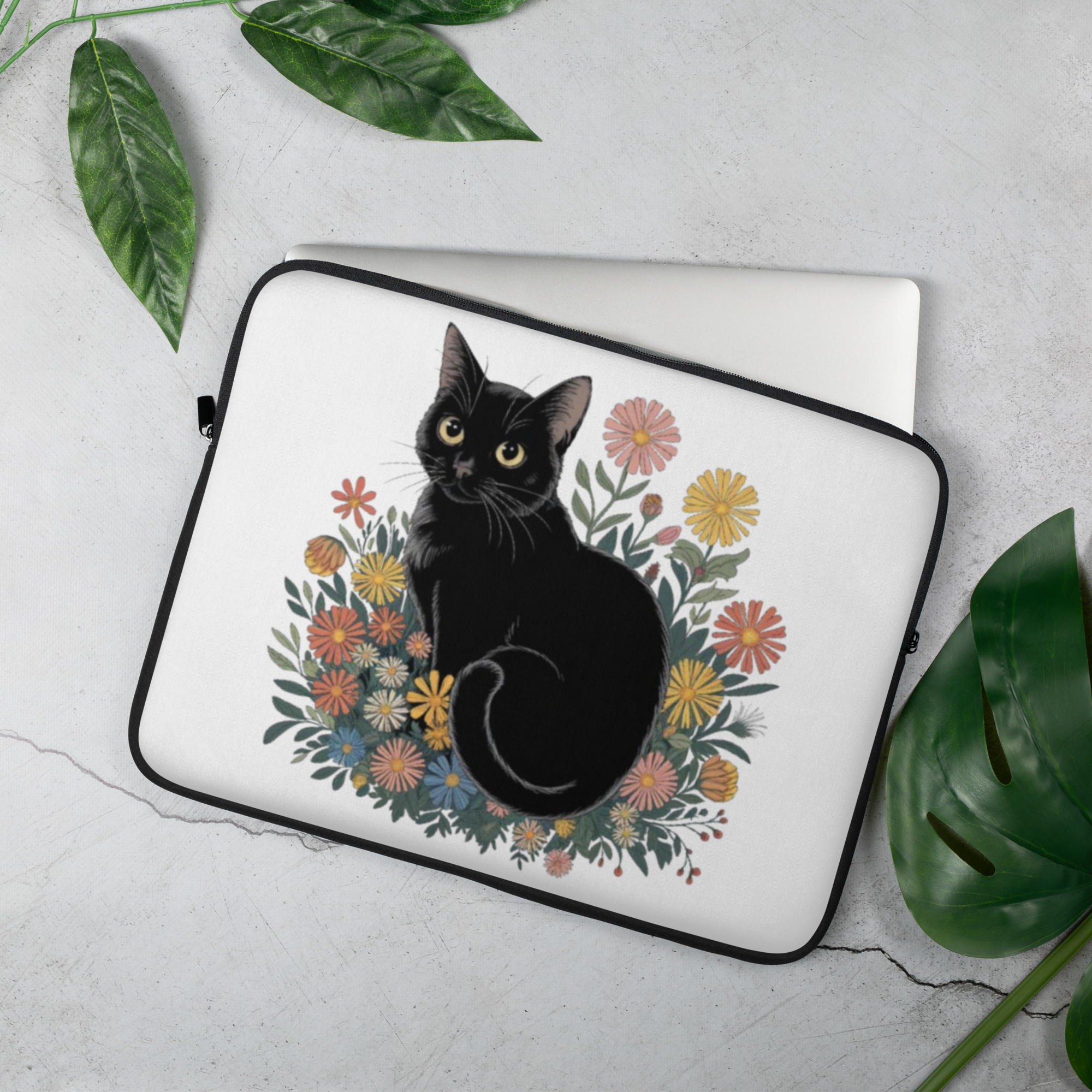 Cat laptop sleeve, 15″: black cat in a wildflower bouquet on a white sleeve, gray stone, green leaves, silver laptop peeking out