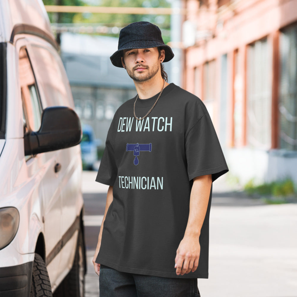 Man in a bucket hat wearing a Faded Black funny astronomer shirt printed with DEW WATCH TECHNICIAN around a small telescope tube with a ringed-planet tag and a hanging water drop