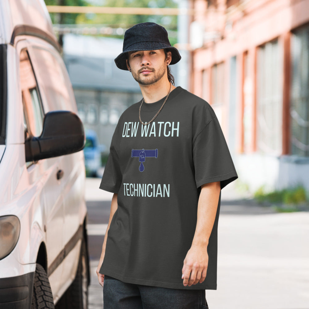 Man in a bucket hat wearing the Faded Coal Dew Watch Technician astronomy tee on a city street