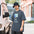Man in a bucket hat wearing the Faded Indigo Find the Gap double star tee on a city street