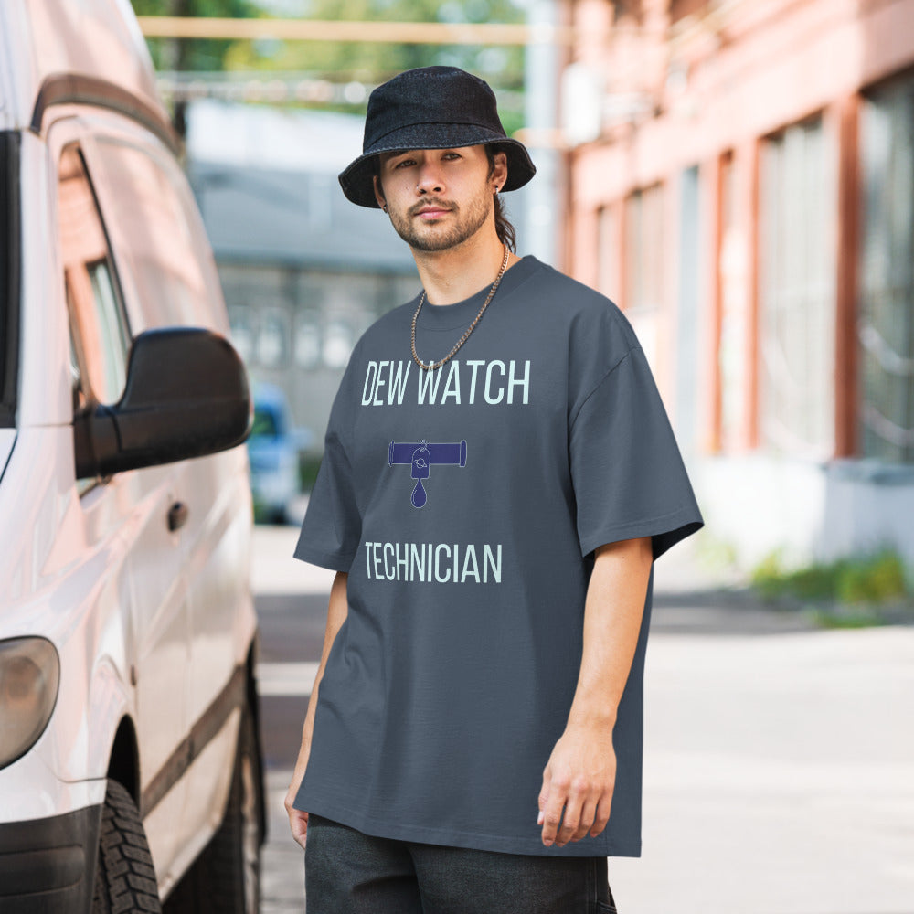 Man in a bucket hat wearing the Faded Indigo Dew Watch Technician astronomy tee on a city street