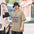 Man in a bucket hat wearing the Faded Khaki telescope shirt beside a parked van, small telescope on a tripod above the words DRIVEWAY DOUBLES DEVOTEE