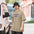 Man in a bucket hat wearing the Faded Khaki Ask Me About My M74 galaxy tee on a city street