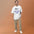 Man wearing the Faded White Rille Survey Crew moon shirt against a warm studio backdrop, front view of the lunar pennant print