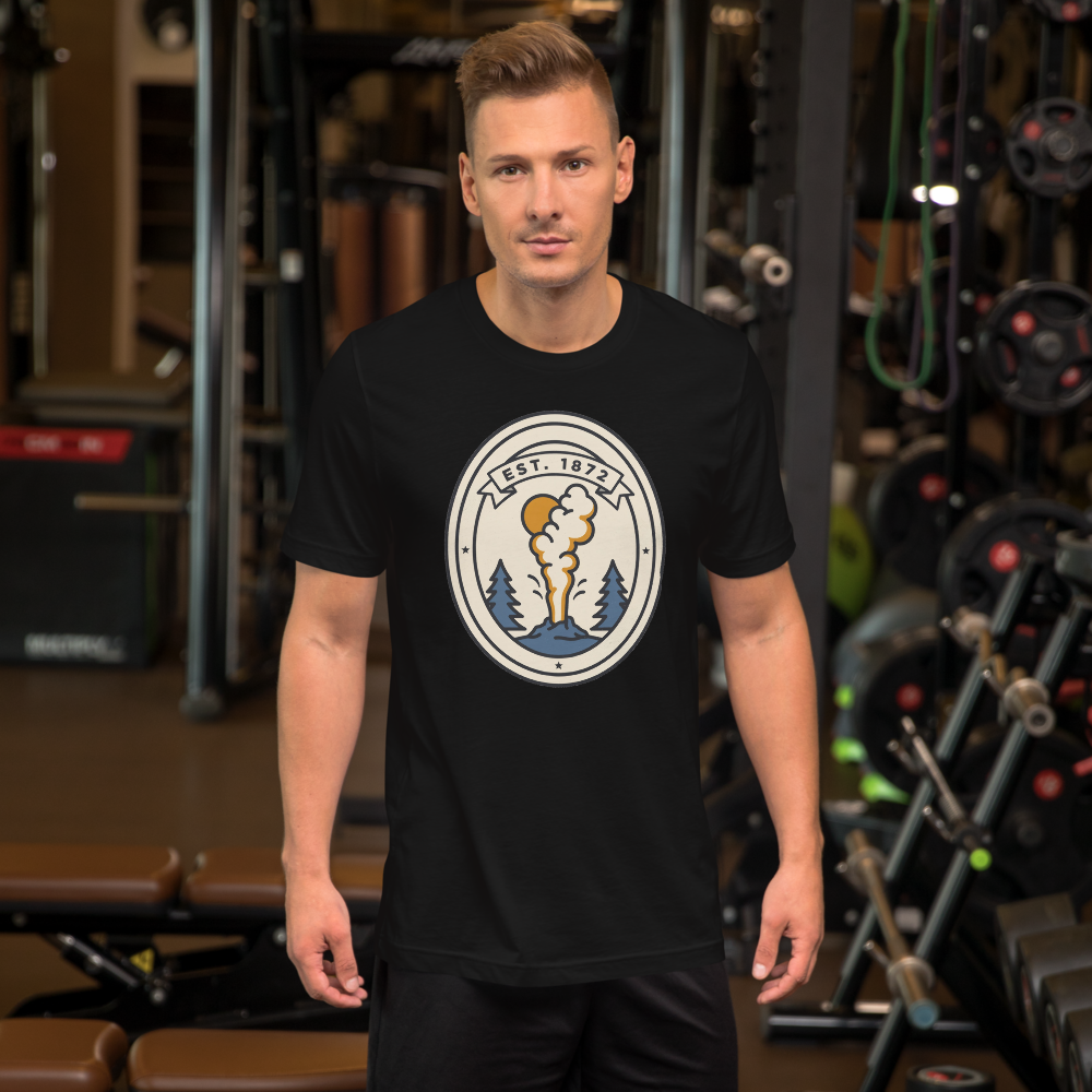 Man wearing the black Est. 1872 geyser badge t-shirt, showing the print scale across the chest