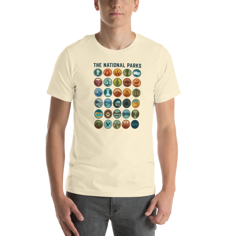 Man wearing the natural cream national parks badge grid t-shirt, showing the print scale across the chest