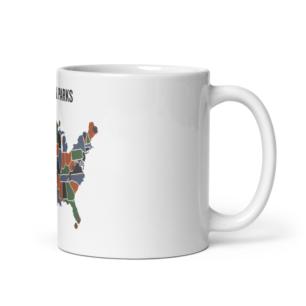 National park map mug shown with the handle on the right, states blocked in sage, dusk blue, rust and charcoal