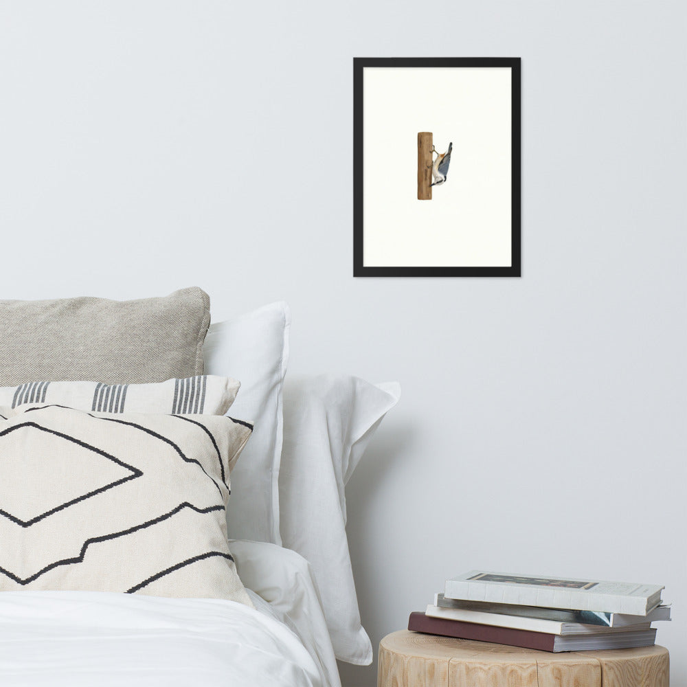 A Different Way Down framed nuthatch print on a bedroom wall above a bed and side table
