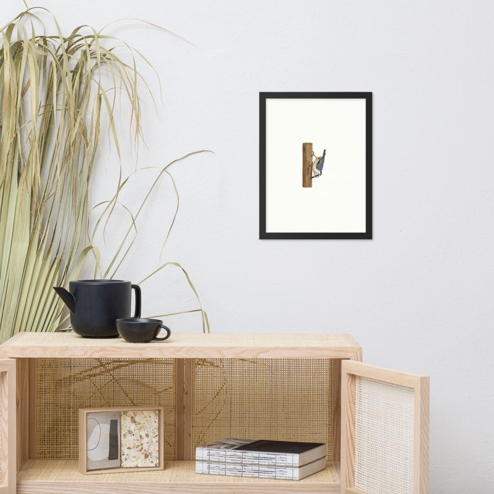 A Different Way Down framed nuthatch print above a rattan sideboard with a teapot and books