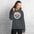 Glacier National Park vintage mountain goat badge hoodie in dark heather grey worn by a woman, front view