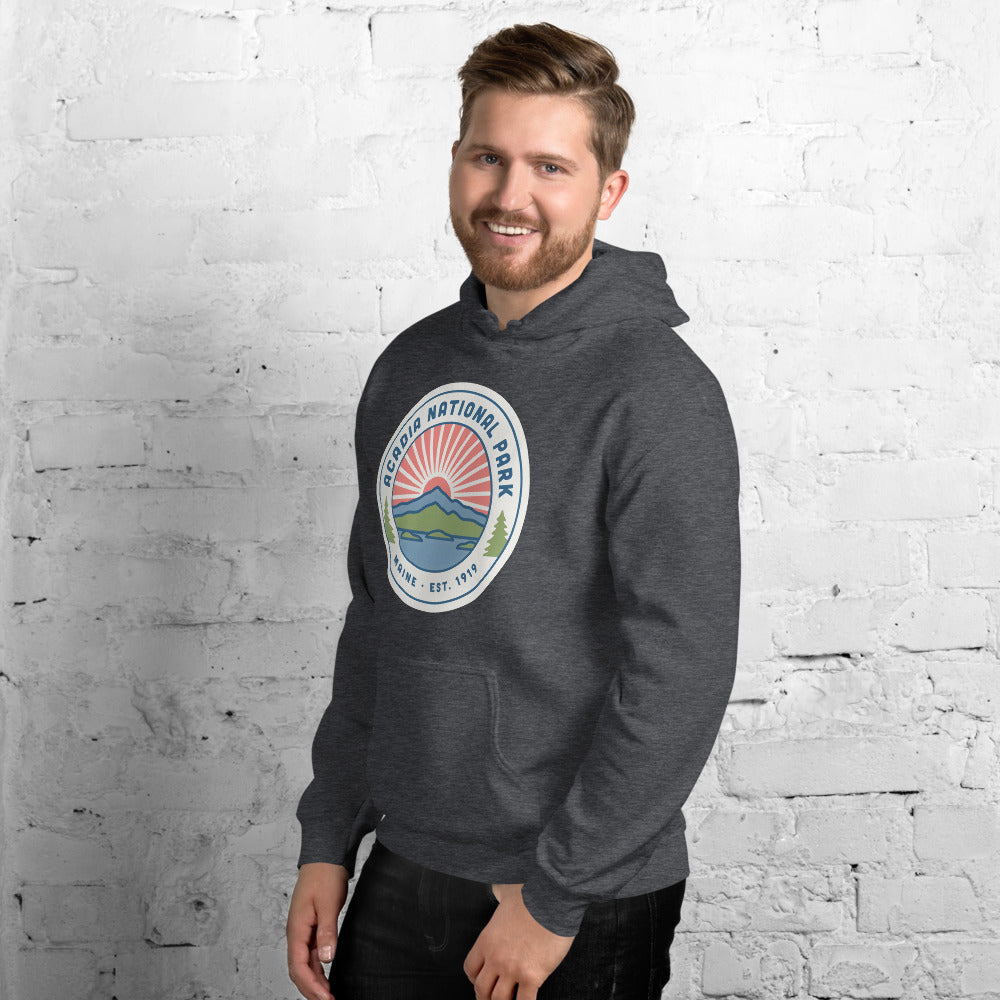Acadia National Park vintage coastal sunrise badge hoodie in dark heather grey worn by a man, side angle
