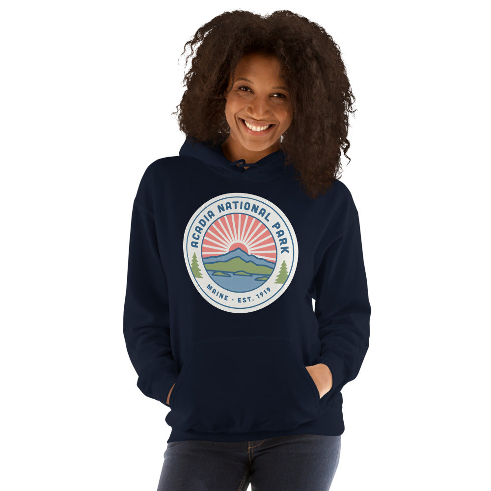 Acadia National Park vintage coastal sunrise badge hoodie in navy worn by a woman, front view
