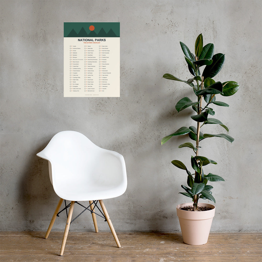 63-park national parks checklist poster on a concrete wall above a white chair and rubber plant