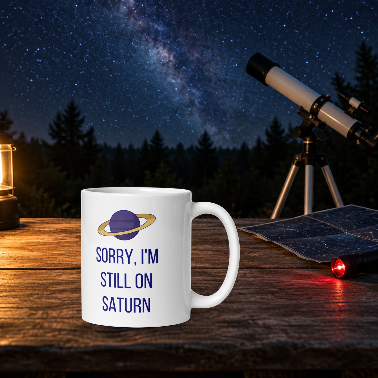 Sorry, I'm Still on Saturn mug on a wooden observing table at night, a white telescope, star chart and red flashlight beside it under the Milky Way