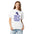 Woman wearing the White lunar observer shirt, front view, printed with binoculars drawn as a ticket casting a long shadow above I CAME FOR CRATERS; STAYED FOR SHADOWS