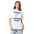 Woman wearing the White constellation shirt, front view, printed with a ribbon knotted around three stars between the words Pattern and Learning Circle