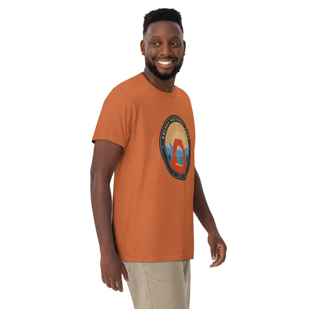 Arches National Park badge tee worn by a model in Yam, side angle