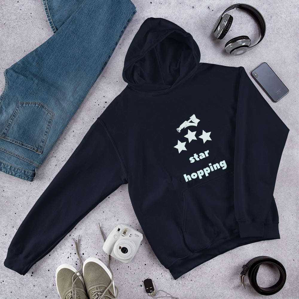 Navy Star Hopping hoodie laid flat with jeans, headphones and sneakers, telescope and three stars design