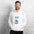 Man in the white Field Work astronomy hoodie by a white brick wall, front view of the notebook print