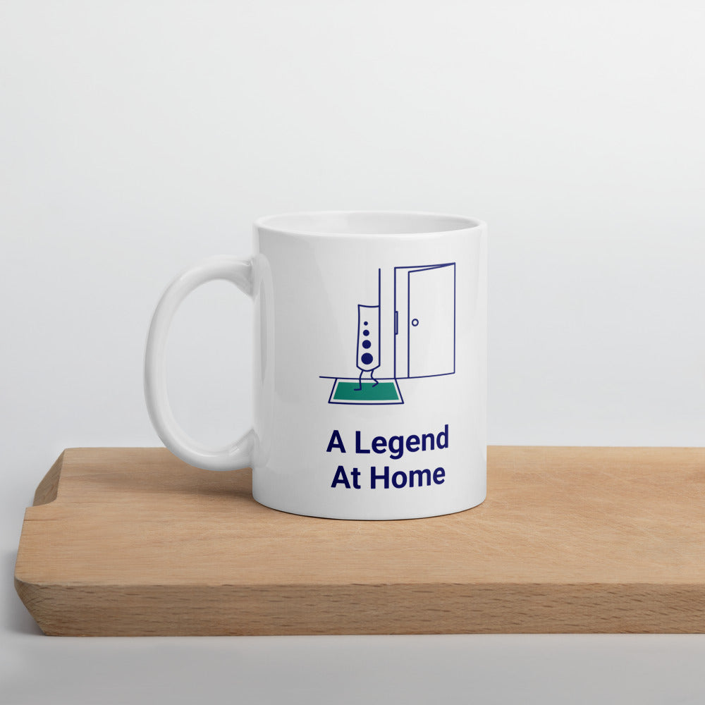A Legend at Home star atlas mug standing on a wooden board, chart legend and open door above the navy lettering