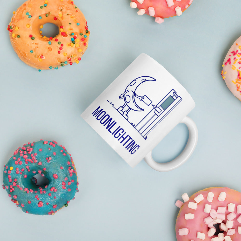 Moonlighting moon mug lying among sprinkled donuts on a pale blue table