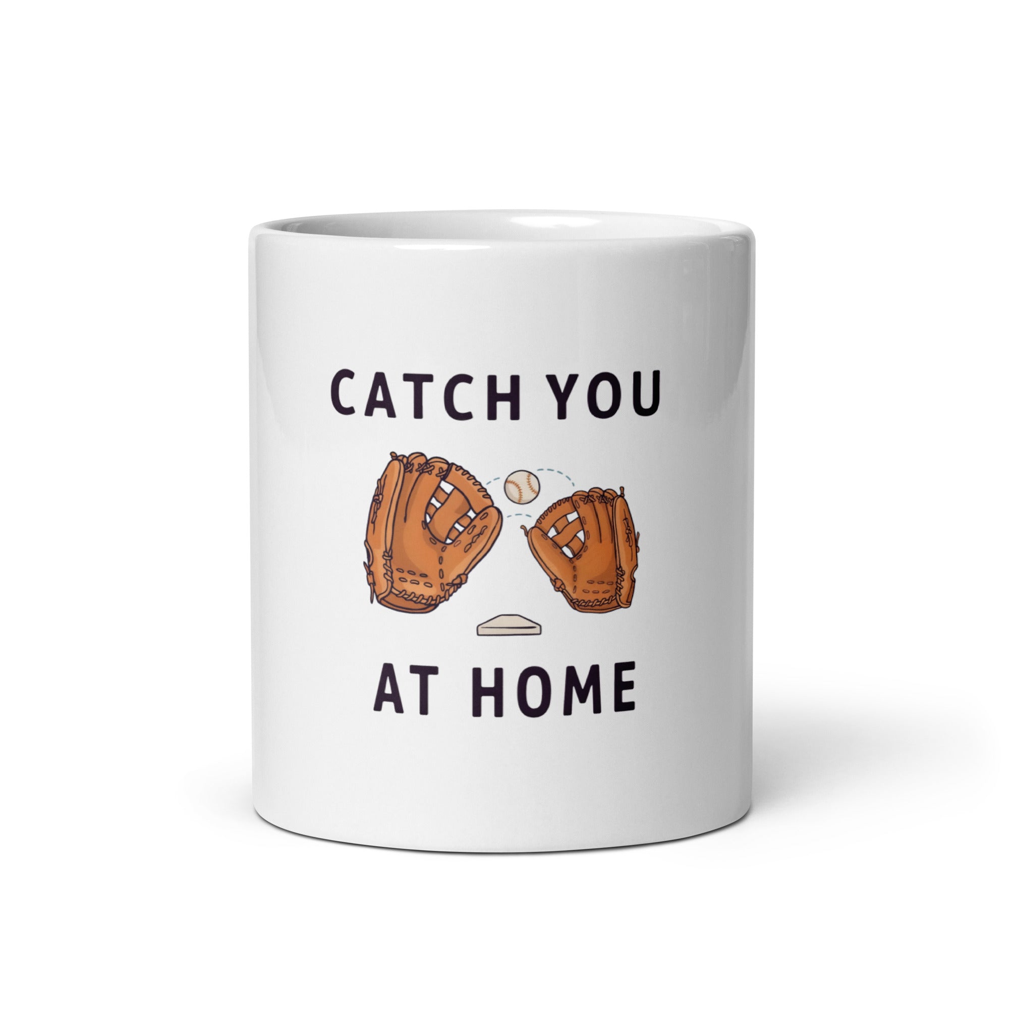 White 11 oz baseball dad mug, front view, with Catch You at Home lettering, two brown gloves, one ball and a home plate.